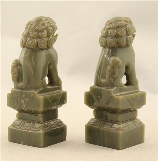 A pair of Chinese spinach green jade lion-dogs and a pair of jadeite figures of elephants, 20th century, 9.5cm, one wood stand